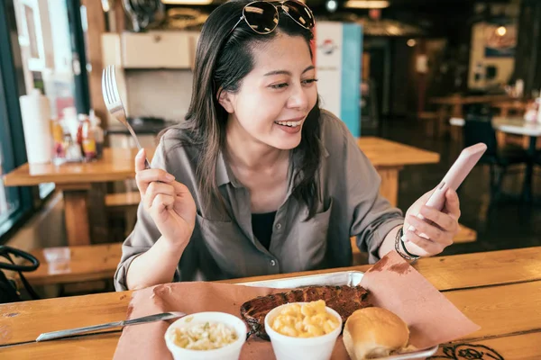 Jovencita Sosteniendo Tenedor Mirando Alegremente Teléfono Celular Mujer Asiática Almorzando —  Fotos de Stock