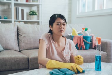 ev işi yaparken rahatsız kahya. onun omuz ağrıyor yüzünden acı yüzü olan ev kadını. Genç Bayan temizlik bezi duygu hasta iken silme mermer tablo.