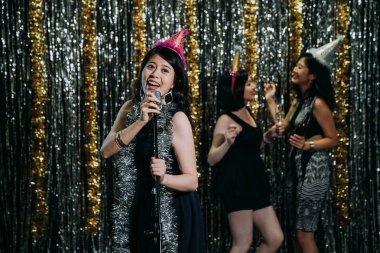 Asyalı kadınlar Grup performans gece kulübünde sahneye sahip. Genç şarkıcı mikrofon söylüyor şarkıları ve dansçı arka planda tutan alkol ile dans müzik keyfini çıkarın. kızlar gece yaşam tarzı clubbing.