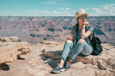 Amerika'nın Büyük Kanyon Ulusal Parkı keşfetmek güzel kız backpacker. Genç Bayan rahatlatıcı ve lojman yere gezi doğa bitmiş. mavi gökyüzü konsepti ile yaban hayatı seviyorum.