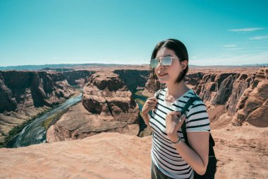 Mutlu Genç Asyalı Çinli kız öğrenci birleştirmek at nalı bend zammı Tur sırt çantası. Gezi seyahat doğada gülümseyen şirin yetişkin kadın backpacker. Bayan zevk çöl vahşi görünümünü güneşli günde.