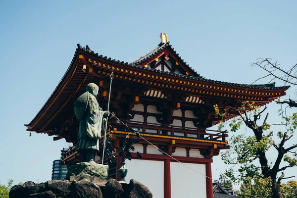 石天王寺的古代铁佛像 美丽的红色寺庙与砖屋顶站在阳光明媚的日子与蓝天的背景 和平的地方没有人户外和绿色的树木植物 — 图库照片