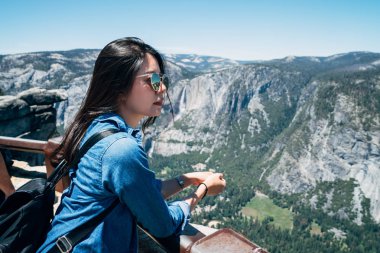 Yosemite Milli Parkı gezi turist kadın California popüler cazibe. Küpeşte rahatlatıcı güvenerek genç bayan hiker yaz aylarında dağ ve orman güzel doğa manzarasına zevk.