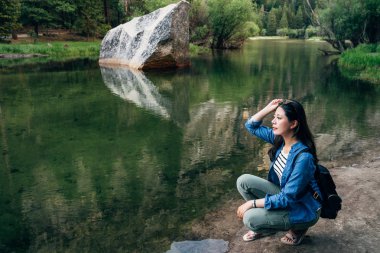 Doğa afiş kadın Yaz Sarayı ayna göl manzaralı yosemite Milli Parkı içinde rahatlatıcı aşağı diz çökmüş. Asyalı kız seyahat ABD aşk vahşi doğa yaşam tarzı kavram. Güneş gözlüklü kadın backpacker