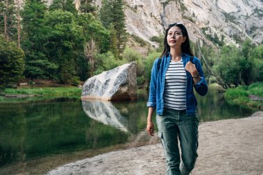 Tatil yosemite Milli Parkı doğa muhteşem manzara seyahat yolculuk tutkusu kadın fiyatı hiking. güzel ayna göl kenarında ormanın su büyük bir kaya ile dağ altında.