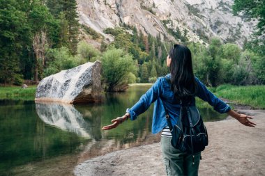 arkadan görünüşü doğa silah açma özgürlüğü kadın. kaygısız kız seyahat zevk aşk vahşi gezi yakınındaki yosemite Milli Parkı gölde ayna tarafından rahatlatıcı. Genç Asya seyahat tatil yaz
