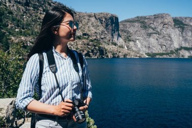 Asyalı Çinli Bayan fotoğrafçı güneş gözlüğü Tur gezi hetch hetchy Reservoir ile. Genç kız uzun yürüyüşe çıkan kimse seyahat yosemite Milli Parkı içinde kamera tutarak san franisco. Doğa ABD gezi.
