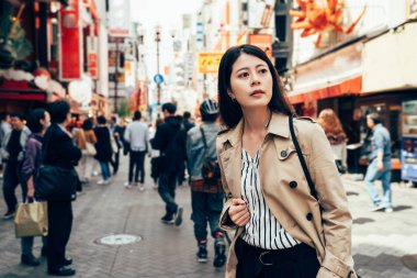 doğru yolu düşünce güzel Bayan gezgin dotonbori osaka Japonya içinde güneşli günde yemeğe sonra otele geri. Genç Asyalı kadın yön ayakta kentsel meşgul sokakta bulma.
