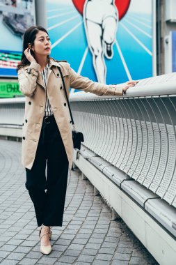 Kentsel genç kadın kat dotonbori köprü geçiş nehre üzerinde yürüyen şehir yaşam tarzı yaşam moda tam uzunlukta. Modaya uygun modern kadın Asya modeli osaka rahatlatıcı Küpeşte ellerini koyarak
