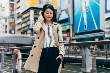 kadın iş işçisi yere yakın nehir aşağı bakıyor. güzel ofis Bayan gülümseyen biri bekleniyor dotonbori ayakta yakınındaki ünlü nippon çalışan adam imzalamak turizm cazibe osaka