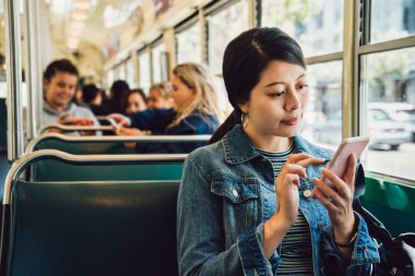 Genç kız üniversite öğrencisi gidip yaşam tarzı kavramı. kadın genç san Francisco hafif raylı ulaşım çekerken internet üzerinden cellphone tarafından öğrenme online. Metro metro içinde oturan kadın.