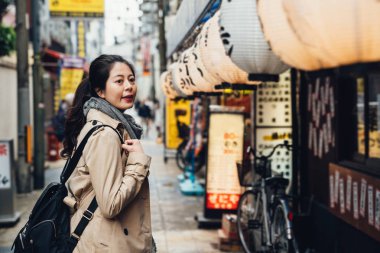 Genç kız gezgin Restoran çatı üzerinde asılı beyaz fener yürürken. kadın turist shinsekai osaka Japonya Japon yerel sokak yemekleri öğle yemeğinde için yer bulmak.