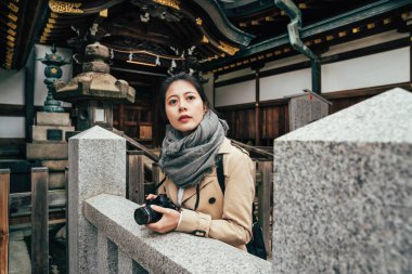 Bayan turist Japon tapınak ziyaret slr kamera tutarak. Japonya'nın osaka tenmangu tapınağında etrafa eşarp genç zarif kız. ahşap taş tarafından yapılan güzel tarihi mimari.