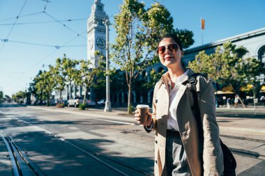 güzel Çinli kadın gezgin gülümseyen holding kahve Kupası ABD bina ünlü cazibe feribot gezi sonra açık havada san Francisco'da teleferik tramvay demiryolu crossing yürüyüş