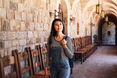 Eski Ortaçağ sokaklarında Yunanistan Kalesi'nde. Genç Asya seyahat etmek taş ve kayalar tarafından yapılan tarihi bina ziyaret etrafında yürüyüş. Kız koridorda neşeyle gezi.
