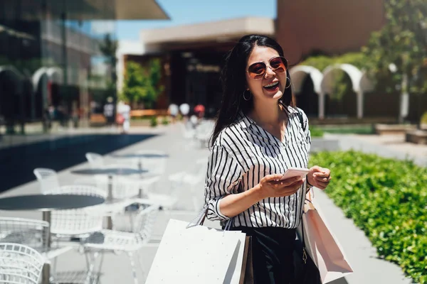 Schöne Mädchen Mit Sonnenbrille Einkaufstaschen Mit Dem Smartphone Der Hand — Stockfoto