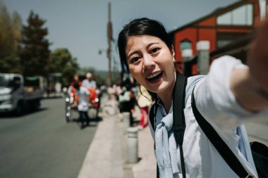 selfie Arashiyama sokak kyoto Japonya'da alarak road yakınındaki ayakta kaygısız genç kız backpacker. mutlu Asyalı kadın gülümseyen güneşli günde iç içedir kasabada çekti çekçek ile kendi kendine portre yapmak.