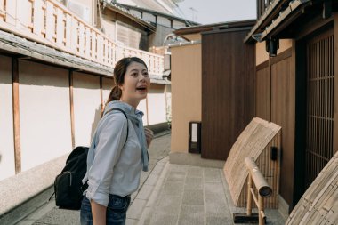 mutlu kız backpacker seyir yukarıya için mavi gökyüzü gülümseyen. Genç Asyalı kadın turist ziyaret Japon Ishibe sokak kyoto Japonya'da. Kadın gezgin ahşap bambu evi kültür bina baktılar.