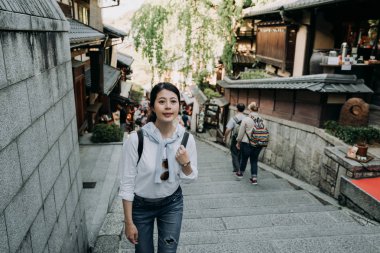 sannen zaka sokak merdivenlerde yürürken tırmanma gülümseyen kız backpacker. birçok yabancı turist ünlü cazibe kyoto Japonya ziyaret. güzel kadın gezgin neşeli ziyaret Japon tarzı eski şehir