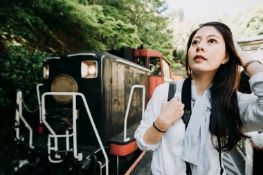 Genç Asyalı kadın gezgin gülümseme fiske uzun siyah saçları. Mavi güneşli gün gökyüzü ayakta Torokko Arashiyama Tren İstasyonu kyoto Japonya demiryolu platformu üzerinde açık isteyen genç yolcu kız