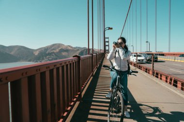 Golden gate köprüsü San Francisco ABD'de gezi bisikleti Bayan. Genç kadın turist güneşli yaz aylarında çekim resim çekim alarak görünümü durmak binicilik bisiklet zevk Bisiklet Tur.