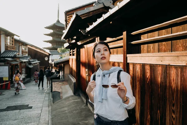 女性の旅行者は三年坂通りの周りを見てサングラスを保持しています 八坂の塔日本スタイルの背景の有名な観光スポット京都の建物します 道路の上を歩く着物を着ている人 — ストック写真