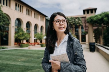 Çekici gülümseyen şirin Asyalı Genç kız öğrenci okul kitap Üniversitesi Açık yürüyüş rahatlatıcı ile. Üniversite Bayan zevk güneş etrafında yeşil çim ve ağaçların tarafından stanford yılında Park.