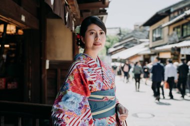 öğleden sonra öğle yemeği sonra restorandan çıkıp muhteşem bir Japon kadın. kiyomizu zaka sokak üzerinde çok sayıda turistin neşeli duran genç yerel kız yürümek. kimono güzel Bayan.