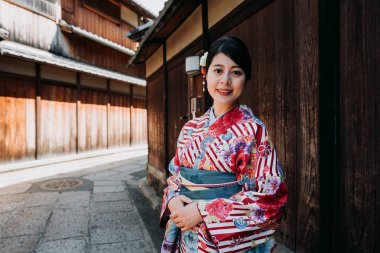 ishibe sokak kyoto Japonya'da yaz aylarında yürüyüş gülümseyen genç yerel Japon kız pembe çiçek kimono yüz fotoğraf makinesi. Geleneksel bahar tarihi ahşap duvar house civarındaki rahatlatıcı içinde kadın.