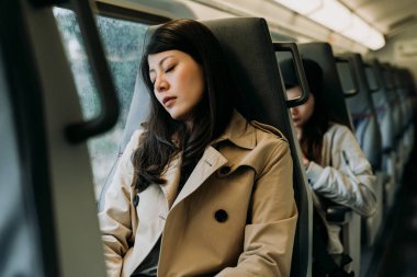 Bir tren seyahat pencerenin yanında uyuyan gezgin kadın. çalışmak için akıllı rahat gidip yorgun Çinli Bayan işçi bir şekerleme almak. Metroda koltukta oturan genç kız sakin yerde uykuya daldı.
