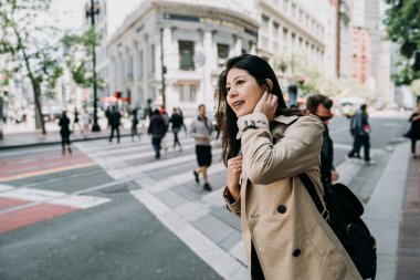 merak yüz kaldırım üzerinde duran gülümseyen kadın Asya Turizm. Zebra üzerinde yürüyen kişi arka planda arası. Genç kadın Yön şehir turu san Francisco Amerika'da bahar tatil bulma.