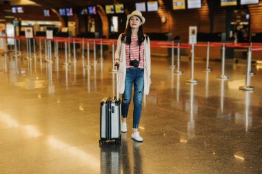 arkadaşlar birlikte Havaalanı lobisinde seyahat fotoğraf makinesi bekleyen taşıyan genç kız backpacker tam uzunlukta. Çinli kadın terminal bavul Bagaj ile ayakta. tatil tatil kavramı ve.