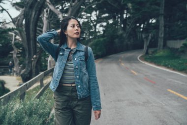 Kendine güvenen Bayan sırt çantası seyahat gezi çevresinde arıyorum 17 mil sürücü yolda yürüyen güzel doğa orman manzaralı. genç Japon kız zevk rahatlayın