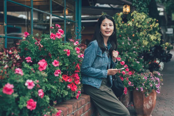 Young Elegant Woman Holding Cellphone Sitting Red Brick Garden Pink — Stock Photo, Image