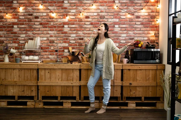 Mujer divertirse bailando y cantando en la cocina — Foto de Stock