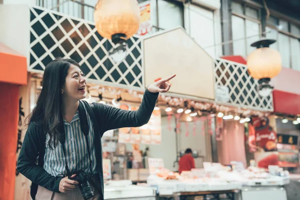 Reisender zeigt auf Verkäufer im Indoor-Markt — Stockfoto