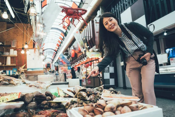 Woman pointing stand selling fresh seafood — Stock Photo, Image