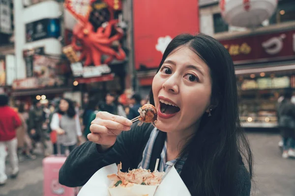 Happy girl on street having local snack takoyaki — Stock Photo, Image