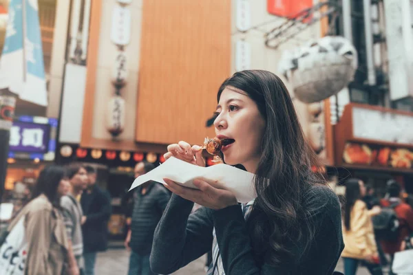 Modelo femenino comiendo albóndigas de pulpo — Foto de Stock