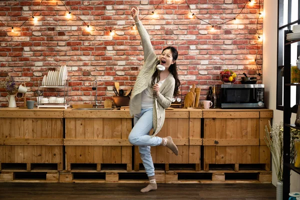 Mujer levantando mano sosteniendo utensilio de cocina — Foto de Stock