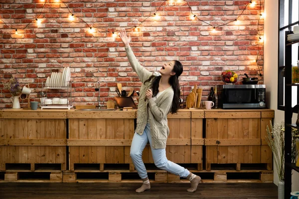 Divertida mujer bailando y cantando con cucharón — Foto de Stock
