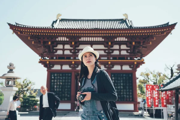 Girl with camera traveling in ancient temple — Stock Photo, Image