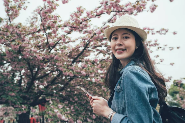 在春天使用智能手机的愉快的妇女 — 图库照片