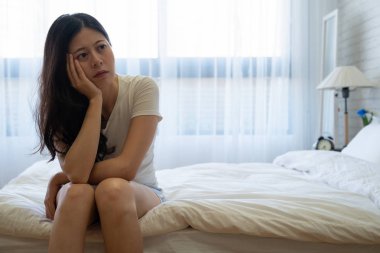 Hüzünlü güzel kadın yatakta oturuyordu vurguladı