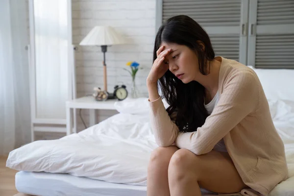 Wanita cina yang khawatir duduk di tempat tidur — Stok Foto