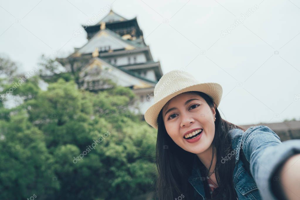 woman hold camera take selfie with osaka castle