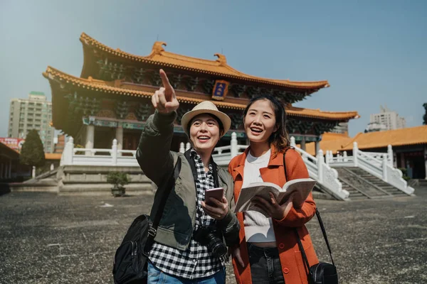 Turisti femminili in possesso di guida cellulare — Foto Stock