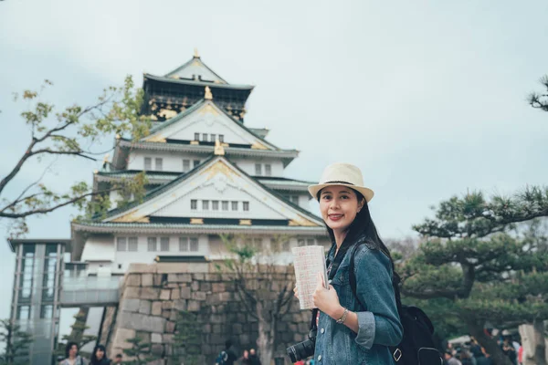 Woman walking around osaka castle with guide book — Stock Photo, Image