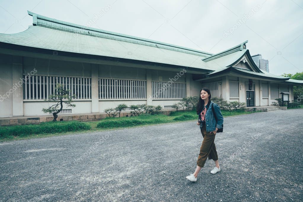 asian lady walking along the old japanese house