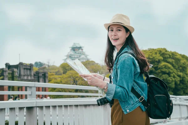 Молодая женщина турист держит бумажную карту — стоковое фото